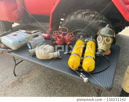 Fire extinguishing accessories. A table with a variety of items including a gas mask and a fire hose. 130231142