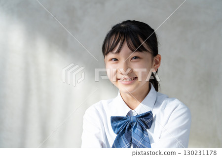 Portrait of a smiling female student in uniform 130231178