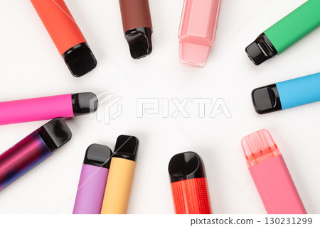 Various colorful disposable vape pens arranged in a circle on white background, modern electronic smoking devices. Various colorful disposable vape pens arranged in a circle on white background, modern electronic smoking devices. 130231299