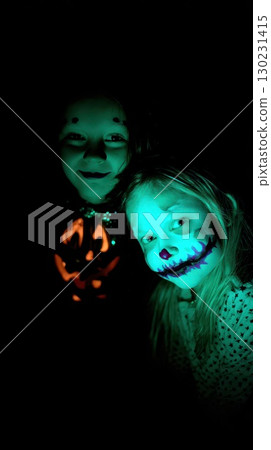 Kids in spooky costumes celebrate Halloween night 130231415