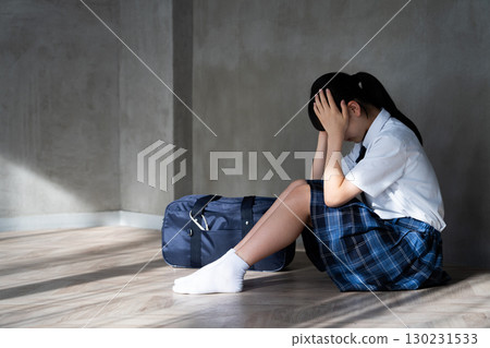 一名女學生蹲下並抱住頭的側視圖 一名女學生蹲下並抱住頭的側視圖 130231533