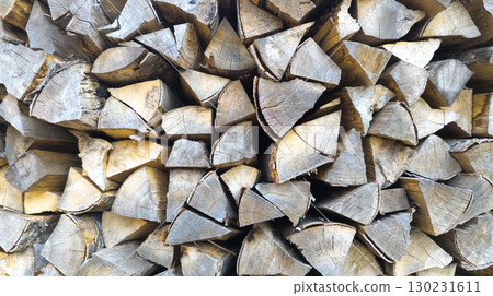 Stacked firewood creating a textured wooden background 130231611