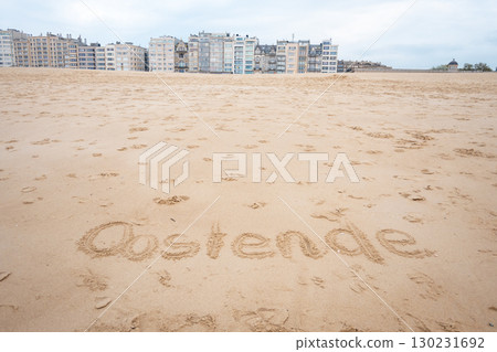 Ostend exclamation word on sea sand. Belgium. Houses, hotel and beautiful walking way. Ostend exclamation word on sea sand. Belgium. Houses, hotel and beautiful walking way. 130231692