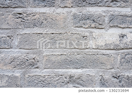 Gray structural stone wall of the ancient building consists of bricks. Nature structural background. Gray structural stone wall of the ancient building consists of bricks. Nature structural background. 130231694