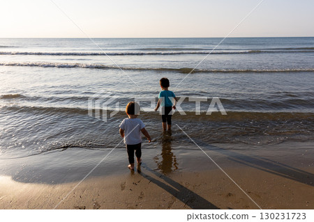 Two children looking at the sea on the beach 130231723