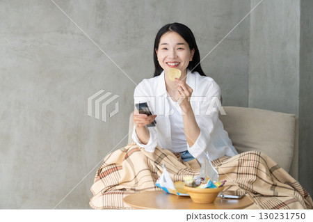 Adult woman enjoying TV on the sofa 130231750