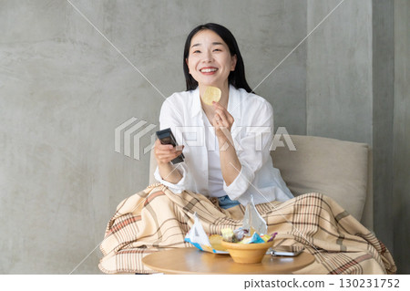Adult woman enjoying TV on the sofa Adult woman enjoying TV on the sofa 130231752