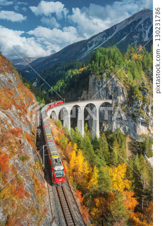 Aerial view of modern red train on Landwasser viaduct Aerial view of modern red train on Landwasser viaduct 130231786