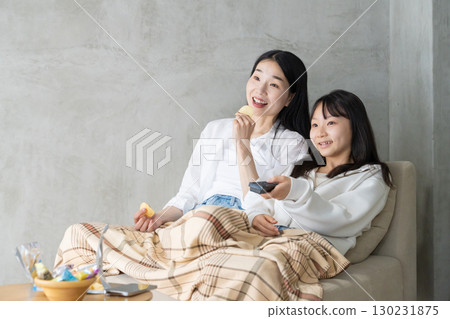 母親和女兒在沙發上一起微笑 130231875