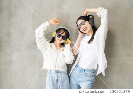 A close parent and child enjoying dancing while listening to music A close parent and child enjoying dancing while listening to music 130231879