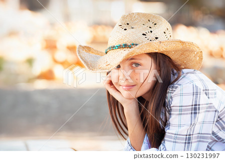 Pretty Girl Wearing Cowboy Hat Enjoying The Pumpkin Patch on a Sunny Fall Day. 130231997