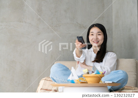 成年女性在沙發上看電視 130232027