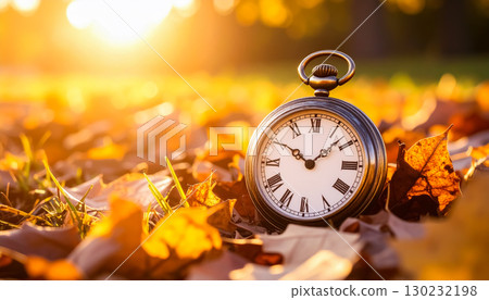 A pocket watch standing amongst fallen autumn leaves / A striking visual element that symbolizes the passage of time and the feeling of the seasons A pocket watch standing amongst fallen autumn leaves / A striking visual element that symbolizes the passage of time and the feeling of the seasons 130232198