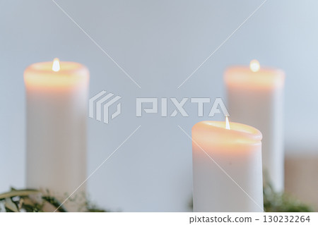 Three burning candles with soft, warm flames create a serene and peaceful atmosphere. The gentle light highlights the contours of the candles, enhancing the ambiance of relaxation. Three burning candles with soft, warm flames create a serene and peaceful atmosphere. The gentle light highlights the contours of the candles, enhancing the ambiance of relaxation. 130232264