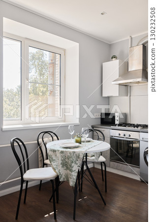 A Cozy Modern Kitchen that features a Dining Area filled with Natural Light and Style 130232508