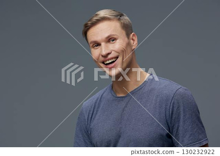 Smiling man digital nomad casual wear blue t-shirt happy positive emotion gray studio background work lifestyle concept Smiling man digital nomad casual wear blue t-shirt happy positive emotion gray studio background work lifestyle concept 130232922