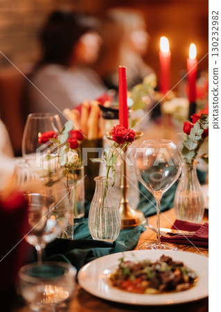 Pouring rose wine into a glass during romantic candlelit dinner with elegant table decor 130232982