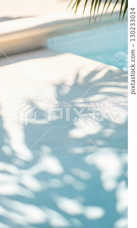Relaxing poolside with palm shadows 130233014