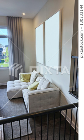 Cozy mockup living room corner featuring a modern sectional sofa with decorative pillows and empty frames on the wall, ideal for interior design inspiration 130233144