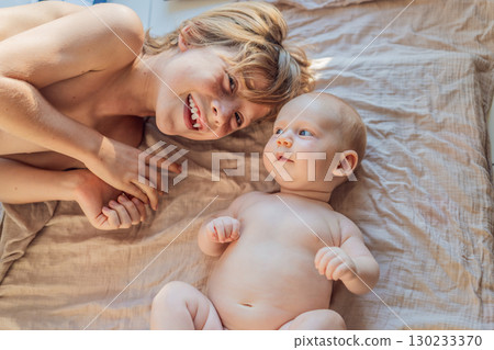 Older and younger baby brothers lying on a soft muslin blanket in warm sunlight, bonding and interacting. Concept of sibling love, early connection, and family warmth Older and younger baby brothers lying on a soft muslin blanket in warm sunlight, bonding and interacting. Concept of sibling love, early connection, and family warmth 130233370