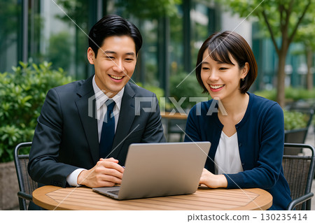Young men and women having a meeting while chatting at an outdoor cafe 130235414