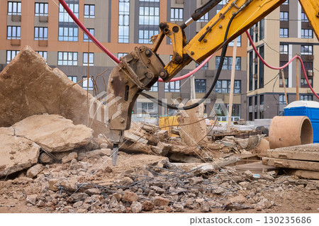 A bustling construction site filled with heavy machinery and ongoing demolition work 130235686