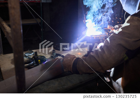 Electric Arc Welding Conducted in a Dimly Lit Space, Showcasing Skill and Precision 130235725