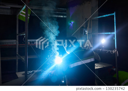 Electric Arc Welding Conducted in a Dimly Lit Space, Showcasing Skill and Precision Electric Arc Welding Conducted in a Dimly Lit Space, Showcasing Skill and Precision 130235742