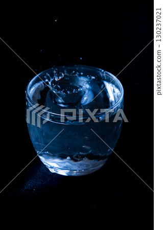 Water splashing from a clear glass on a black background 130237021
