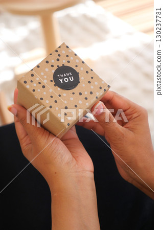 Gift box being opened with thank you note on a sunny day Gift box being opened with thank you note on a sunny day 130237781