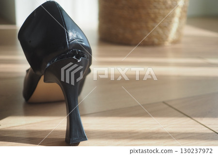Close-Up of a Worn Black High Heel Shoe Damaged at the Heel 130237972