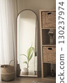 Decorative mirror reflecting green plant in cozy room 130237974