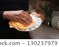 Person cleaning a plate with a cloth in a kitchen setting 130237979