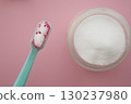 Bright teal toothbrush ready for use with baking soda powder 130237980