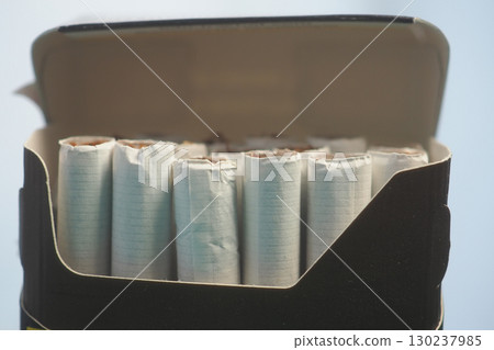 Pack of rolled papers inside a black box on a light surface Pack of rolled papers inside a black box on a light surface 130237985
