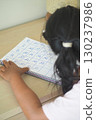 Child practicing numbers at a home learning table 130237986