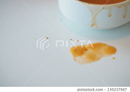 Spilled soup on a clean white table surface Spilled soup on a clean white table surface 130237987