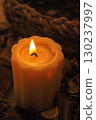 Flickering flame illuminates a candle in a cozy atmosphere 130237997