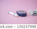 Diabetes tools on a pastel pink surface. glucose meter and supplies 130237998