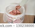Organizing laundry in a mesh basket at home 130238000