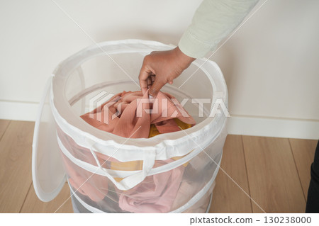 Organizing laundry in a mesh basket at home 130238000