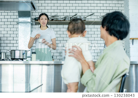 Mom cooking in the kitchen and dad taking care of the kids Mom cooking in the kitchen and dad taking care of the kids 130238043