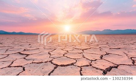 Vibrant Desert Landscape with Cracked Earth and Colorful Sunset Sky at Dusk 130238394