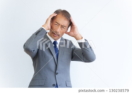 Senior businessman holding a head Senior businessman holding a head 130238579