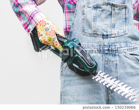 Cute woman, work clothes and hedge trimmer. Studio shot. Cute woman, work clothes and hedge trimmer. Studio shot. 130239066