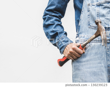 Cute woman, work clothes and hammer. Studio shot. 130239123