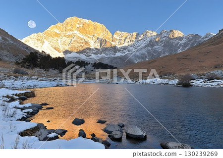 Snowy Mountain Lake at Sunrise with Moonlit Peaks 130239269