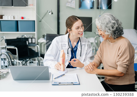 Doctor in white suit take notes while discussing and Asian elderly, man patient who lying on bed with receiving saline solution 130239388