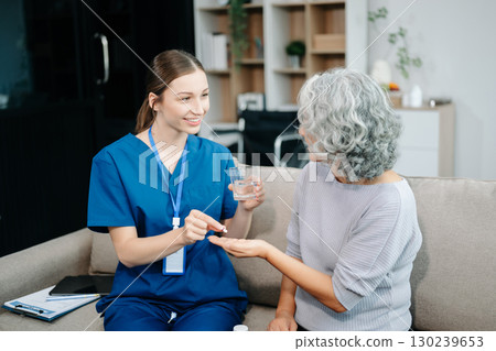 Caregiver doctor examine older patient use blood pressure gauge. woman therapist nurse at nursing home taking care of senior elderly woman sit on sofa. Caregiver doctor examine older patient use blood pressure gauge. woman therapist nurse at nursing home taking care of senior elderly woman sit on sofa. 130239653