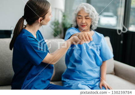 Physiotherapist helping elderly woman patient stretching arm during exercise correct in hand during training hand with patient Back problems Physiotherapist helping elderly woman patient stretching arm during exercise correct in hand during training hand with patient Back problems 130239784